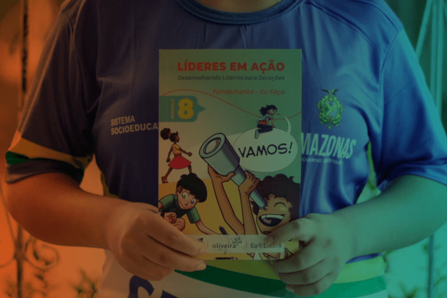 Jovem segurando o livro Líderes em Ação do programa Eu Lidero